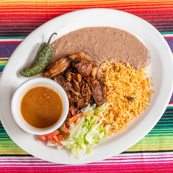Chula on Broadway's Mexican carnitas plate with rice, refried beans, salsa, and a jalapeño.